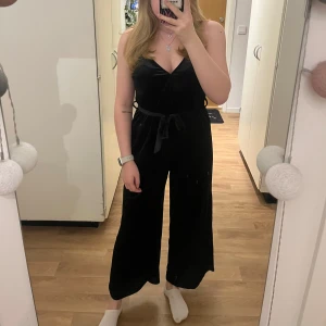 Byxdress - Svart byxdress i velour med snöre runt midjan och en knapp vid brösten, stretchigt tyg☺️ Väldigt fint skick💗