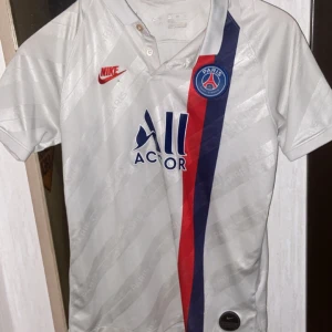 PSG T-shirt - Vit PSG t shirt som är äkta och sälj inte längre men använder inte längre. Priset går att diskuteras. Den är storlek 170 och använd typ 3 gånger. 