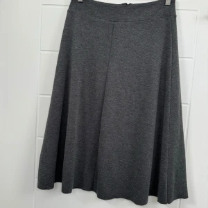 En vackra kjol från Åhléns. Helt ny. - Denna vackra kjol från Åhléns. Helt ny och oanvänd.   Storlek 36/38 (S) Med en längd på 70 cm är den perfekt för både vardags- och kontorsbruk.  Priset är endast 79 Kr.