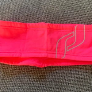Rosa träningsheadband - Säljer ett snyggt headband som är perfekt för löpning eller annan träning, eller bara till vardags. Reflexdetalj. Mjukt material på insidan. Helt nytt. 