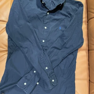 Marinblå Ralph Lauren Skjorta - Marinblå skjorta av Ralph Lauren, storlek s i slim fit, mycket bra skick utan defekter