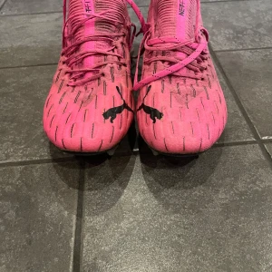 Rosa fotbollsskor från Puma - Säljer ett par puma future nästan helt oanvända. Säljer då de är förstora. Det är skruvdobbar. Skick 9/10