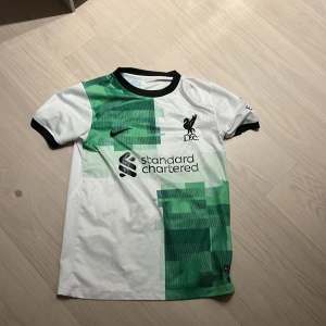 23/24 Liverpool borta tröja - Säljer en riktig snygg Liverpool 23/24 borta tröja. Såklart är den äkta med tryck på baksidan med Szoboszlai 8. Hör av er vid frågor😁