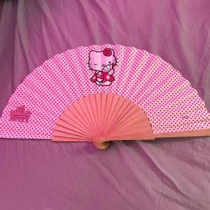 Hello kitty Solfjäder  - Säljer denna super söta solfjäder med hello kitty på då den aldrig kommit till användning och bara legat i en låda under sommaren. Köpt i spanien förra året. Syns inte super bra på bilderna men bakrunden är vit.