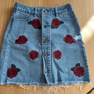 Jeans kjol med rosor  - Kjolen är från nakd. Kjolen är fortfarande bra skick och har använts få tal gånger. 