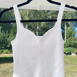 Vitt ribbat linne - Ett vitt ribbat linne från H&M i storlek XS. Extremt stretchig och passar säkert upp till storlek M 🤩 Använt max 5 gånger  🌸  Längd: 38 cm Axel: 25 cm