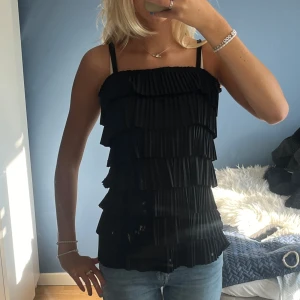 Festtopp  - Jättefin svart topp med volanger som passar perfekt till fest🖤Banden går även att ta bort och använda som tubtopp    Säljer då den inte kommer till användning längre 