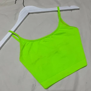 Neongrön topp 💚 - Cool neontopp 💚 Fint skick förutom några mystiska fläckar på sidorna, ej så synligt. Går nog att ta bort med fläckborttagning 💚Strl XS men mycket stretch så går att ha med större storlekar 