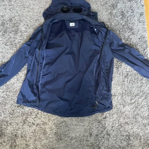 Cp company vindjacka - En sjukt fet cp Company vindjacka med avtagbar luva, bra skick och sparsamt använd. Vid frågor är det bara höra av dig mvh 