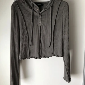 Grå ribbad hoodie från Cider - Säljer en långärmad snygg hoodie. Tunnt material och slutar ungefär vid naveln (172cm). Använt fåtal gånger. Sitter som M