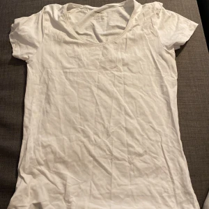Vit t-shirt från H&M - Säljer en enkel och stilren vit t-shirt från H&M. Den är kortärmad och gjord i ett mjukt bomullsmaterial. Perfekt basplagg för vardagen! 💫 skrynklig men enkelt att lösa!