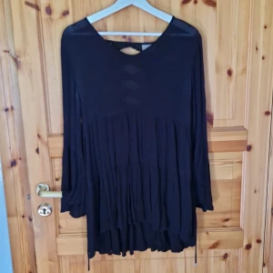 Svart långärmad topp med spetsdetaljer - Säljer en svart långärmad topp med vackra spetsdetaljer på ryggen. Toppen har en lös passform och är perfekt för höst och vinter.