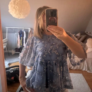 Jättefin blå blus med paljetter!! - Säljer en jättefin blå blus med paljetter och spetsdetaljer. Den sitter jättefin och är luftig i ärmarna. Org pris är 1200kr men köpt för 800kr! Jättebra skick!!✨säljer då den inte kommer till användning. 