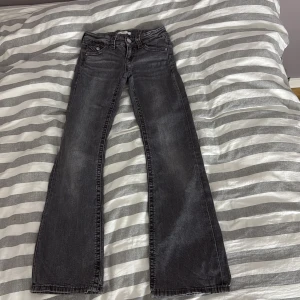 Svart jeans från Gina Tricot - Snygga svarta jeans från Gina Tricot i storlek 146. De har en klassisk femficksdesign med knappar och dragkedja framtill. Perfekta för en stilren look.
