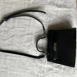 Svart axelväska med metallspänne - Snygg svart axelväska 