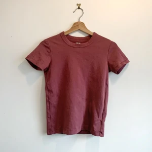 Rosa t-shirt från Uniqlo - Säljer en stilren rosa t-shirt från Uniqlo i storlek S (ungdomsstorlek). T-shirten är kortärmad och tillverkad i mjukt bomullsmaterial. Perfekt för en avslappnad look.