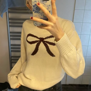 Vit tröja med rosett - helt ny utan lapp från gina tricot🌞Säljer en söt vit tröja med en brun rosett på bröstet. Tröjan har långa ärmar och ribbade muddar vid ärmslut och nederkant. Perfekt för en mysig dag!