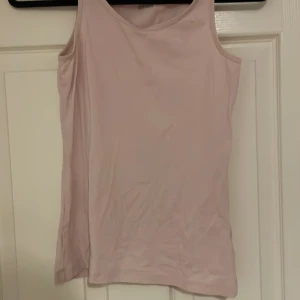 Ljusrosa linnetopp från KappAhl - Säljer en ljusrosa linnetopp från KappAhl, tillverkad i ekologisk bomull. Perfekt för varma dagar med sin enkla och stilrena design. Toppen har en klassisk passform och är ärmlös.