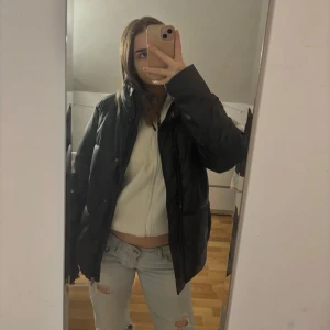 Svart pufferjacka - Säljer min svarta pufferjacket, det är väl omhändertagen bortsett från den lilla skadan på höger bröst ( se sista bild ) 