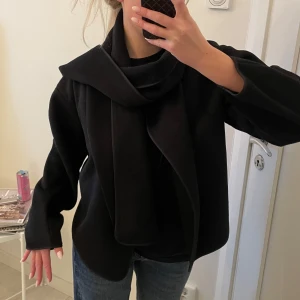 Svart kappa med scarf - Svart kappa/jacka med scarf. Svarfen är avtagbar. Använd en gång! Relativt tunn