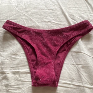 Glittrig rosa bikiniunderdel - Snygg och glittrig rosa bikiniunderdel. Perfekt för att glänsa på stranden eller vid poolen. Den har en perfekt passform! 