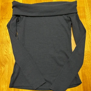 Oanvänd offshoulder topp från Gina Tricot - Snygg blå ribbad offshoulder topp från Gina Tricot. Perfekt för en stilren look med långa ärmar och en bekväm passform. En tröja som är helt ny och bara legat i garderoben tyvärr