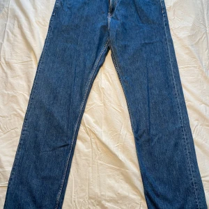 Blå jeans från H&M - Säljer ett par blå jeans från H&M i relaxed fit. De har en klassisk design med fem fickor och en bekväm passform. Perfekta för en avslappnad stil.