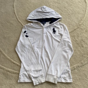 Vit hoodie från Ralph Lauren - Säljer en stilren vit hoodie från Ralph Lauren med den klassiska broderade loggan på bröstet och en stor siffra 3 på ärmen.  Hoodien har inga defekter. Skriv gärna vid ytterligare frågor⚜️