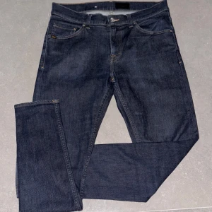 Mörkblå jeans från ToS - Snygga mörkblå jeans från Evolve, tillverkade i Italien. De har en klassisk femficksdesign och en knappgylf. Perfekta för en stilren look. Storlek är 31/34 och modellen heter Evolve😊
