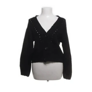 Svart kofta med knappar - Snygg svart kofta med knappar framtill. Den har en croppad passform och långa ärmar. Perfekt för en avslappnad stil.