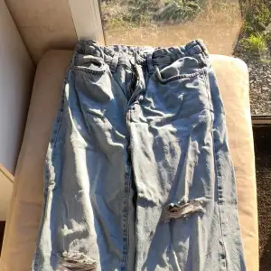 Snygga blå jeans från lager 157 med slitna detaljer på benen. De har en klassisk femficksdesign och en bekväm passform. Perfekta för en avslappnad stil.