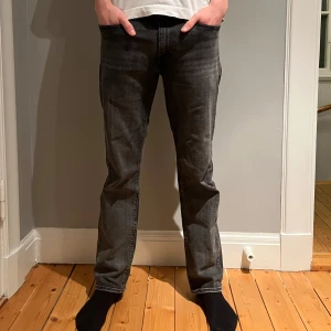 Levis 514  - Snygga svarta jeansbyxor med en klassisk straight passform. De har en midwaist design och är perfekta för en avslappnad stil. Byxorna har en dragkedja och knappar framtill.