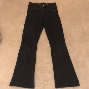 Svarta bootcut jeans från LAB Industries - Snygga svarta bootcut jeans från LAB Industries. De har en klassisk femficksdesign och är tillverkade i ett hållbart denimtyg. Perfekta för en stilren look.