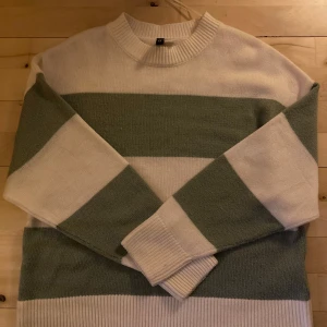 Randig stickad tröja - Säljer en mysig stickad tröja med breda ränder i vitt och grönt. Köpt på H&M för 150, säker för 60<3