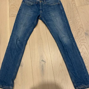 Blå jeansbyxor - Snygga dondup jeans med klassisk femficksdesign och knappgylf. Storlek 33 sitter som 32. Passar någon från 180-185. Modell George. Ny skick inga defekter. Tar emot byten, köparen står för frakt.