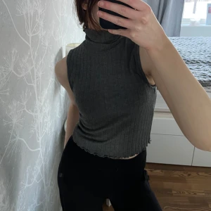 Polotopp - Snygg grå ribbad polotopp med ärmlös design. Använd endast 1 gång☺️