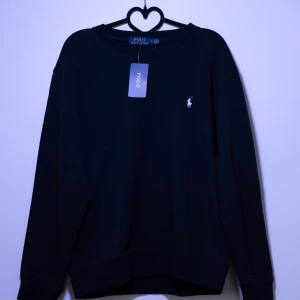 Ralph Lauren Sweatshirt - Snygg svart tröja från Polo Ralph Lauren med klassisk design och broderad logga på bröstet. Perfekt för en stilren look.