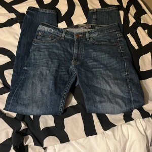 Blå jeans från Dressman - Snygga blå jeans från Dressman med klassisk femficksdesign och knappgylf. Regular fit men sitter mer åt slim fit. Nypris 700kr. 31/32
