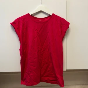  t-shirt - Säljer en enkel och stilren rosa t-shirt med korta ärmar. Perfekt för en avslappnad look. Passar bra till jeans eller shorts. Den ser väldigt röd ut på bilden men den är rosa💕