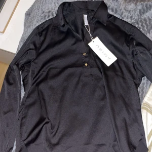 Svart långärmad skjorta - Snygg svart långärmad skjorta från Amisu med klassisk krage och knappar framtill. 