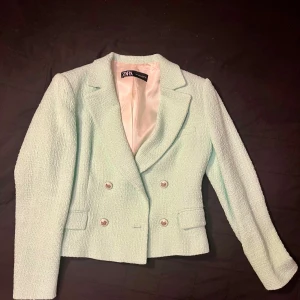 Mintgrön kavaj från Zara - Snygg mintgrön kavaj från Zara med dubbelknäppning och stilrena knappar. Den har en klassisk krage och är helfodrad med ett ljust innerfoder. Perfekt för att ge en fräsch touch till din outfit.