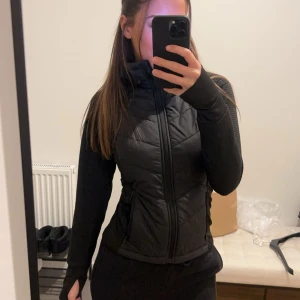 Svart jacka - Snygg svart jacka med dragkedja. Jackan har långa ärmar och en tight passform, perfekt för kyligare dagar. Den är perfekt till promenader och träning