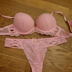 Rosa spetsunderkläder - Säljer ett set med rosa spetsunderkläder, BHn är endast använd 1 gång och trosan är oanvänd i storlek S. BH:n har vadderade kupor och justerbara axelband. Trosorna har en söt rosett framtilloch dekorativa banddetaljer på sidorna. Säljer hela sättet för 70kr