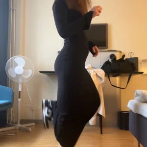 Svart långklänning - Snygg svart långklänning med långärmad design. Perfekt för en elegant look. Klänningen har en tight passform som framhäver figuren.