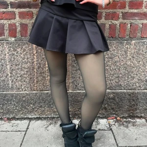 Svart kortkjol med volang - Svart plisserad mini kjol. Perfekt för att skapa en stilren look. Kjolen har en klassisk passform och är lätt att matcha med olika toppar. Kjolen har inbyggda shorts. Skickas samma dag🫶🏼