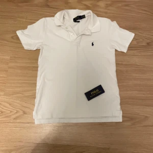 Vit pikétröja från Ralph Lauren - Säljer en snygg Ralph lauren Piké | Storlek 152 men sitter XXS | En defekt(se bild 5) | Priset är ej hugget vid snabb affär | Hör av er vid frågor och funderingar |