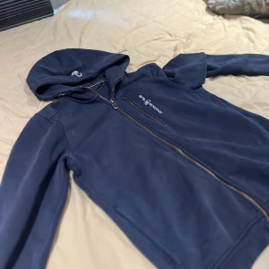 Sail Racing Zipup - Säljer nu min sailracing hoodie ända som har hänt e ena zipupen vid bröstet har lossnat. Den e storlek 176 men passar även mig som e 186!