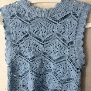 Blå stickad topp från ONLY - Säljer en snygg blå stickad topp från ONLY med ett unikt mönster. Toppen har ribbade kanter och en rund halsringning. Perfekt för lager-på-lager-stil! Aldrig andvänder så den är i nytt skick! storlek xs 