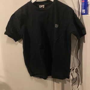 Svart t-shirt med tryck från Minus Two - Snygg svart t-shirt med ett coolt tryck från Minus Two. T-shirten har korta ärmar och en normal passform. Perfekt för en avslappnad stil.