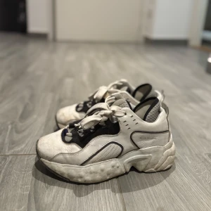 Acne studios sneakers - Snygga vita och svarta sneakers med tjock sula och snörning. Perfekta för en casual look med en modern touch.